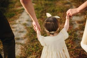 Семья, мама, папа, дочь гуляют на холме в поле