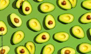 Fresh avocado pattern on a green background flat lay фотография Stock